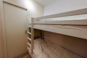 two bunk beds in a small room with a door at Studio 5 personnes au revard in Les Déserts
