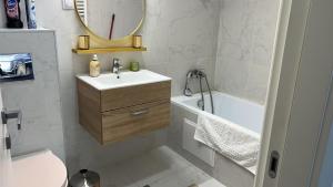 a bathroom with a sink and a toilet and a mirror at Cozy Ivory Studio in Voluntari