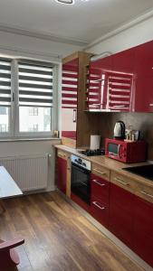 a kitchen with red cabinets and a red microwave at Cozy Ivory Studio in Voluntari