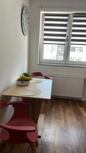 a dining room with a table and chairs and a clock at Cozy Ivory Studio in Voluntari
