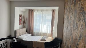 a living room with a bed and a window at Cozy Ivory Studio in Voluntari