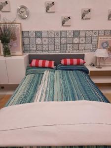 a bed with two red pillows in a bedroom at sleepandgo-selfcheckinout in Weißkirchen in Steiermark +3 photos