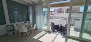 a room with a table and chairs and a balcony at Mary Vi Rooms in Peschici