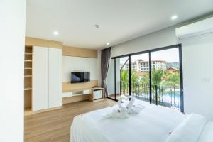a bedroom with a bed and a balcony with a television at PP Garden Home in Sathani Lat Krabang