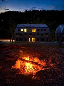 a fire pit in front of a building at night at Muhu Apartments in Velké Hamry +46 photos