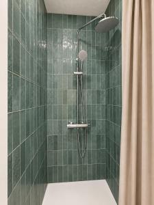 a bathroom with a shower with green tiles at Orange Vibes Guest house in Paterna +70 photos