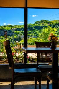 a table and chairs in a room with a window at Hotel Chiatureli in Chiatʼura