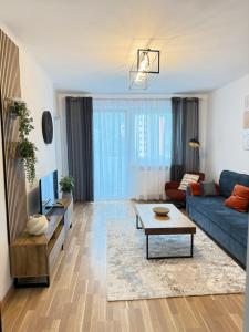 a living room with a blue couch and a table at TSD Living in Kapfenberg