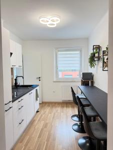 a kitchen with white cabinets and a table and chairs at TSD Living in Kapfenberg