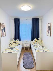 two beds in a room with blue curtains at TSD Living in Kapfenberg