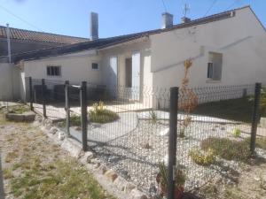 a fence in front of a white house at Escapade proche de l'estuaire in Valeyrac