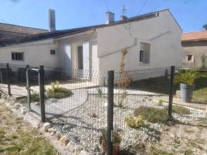 a fence in front of a white house at Escapade proche de l'estuaire in Valeyrac