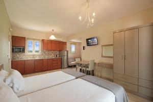 a bedroom with two beds and a kitchen at Megali Luxuries Apartments in Sidari +31 photos