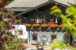 una casa con cajas de flores a un lado. en Der Erlhof Restaurant & Landhotel en Zell am See