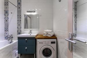 a bathroom with a washing machine and a sink at Appartement Le Mauresque in Arcachon +16 photos