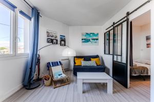 a living room with a blue couch and a bed at Appartement Le Mauresque in Arcachon