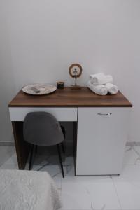 a wooden desk with a plate and a chair at Diamond Suite in Nea Kallikrateia