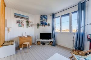 a living room with a large window and a television at Appartement Le Mauresque in Arcachon