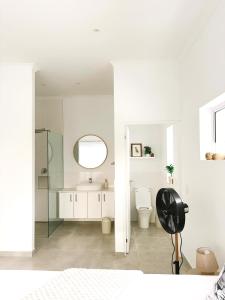 a white bathroom with a toilet and a mirror at Villa Jabulani in Stompneusbaai +43 photos