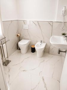 a white bathroom with a toilet and a sink at Boboli Living in Florence
