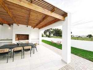 a patio with a table and chairs and a fireplace at Villa Jabulani in Stompneusbaai