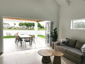 a living room with a couch and a table at Villa Jabulani in Stompneusbaai