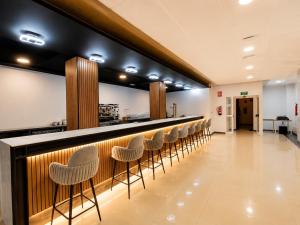 a bar with a row of stools at Hotel Bossh Lido in Benidorm