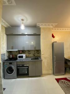 a kitchen with a refrigerator and a microwave at batumi area in Angisa