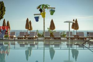 a swimming pool with chairs and umbrellas at Golden Coast Boutique - Luxury Living in Kypseli
