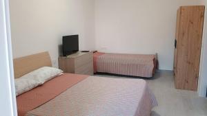 a hotel room with two beds and a television at Locri27 Apartment in Catanzaro Lido