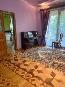 a living room with a piano and a rug at BEAUTI-House in Ijevan