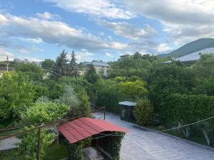 a patio with a red table in a garden at BEAUTI-House in Ijevan