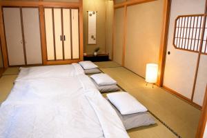 a room with a large bed with pillows on the floor at Sumomo in Takayama