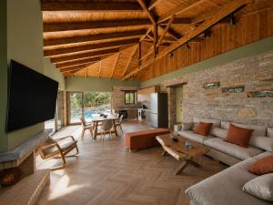 a large living room with a couch and a table at Bellevia Stone Pool Villa in Kouvéllai