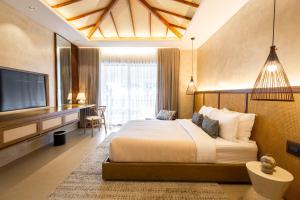 a hotel room with a bed and a television at Golden Sands Destination Resorts in Daanbantayan