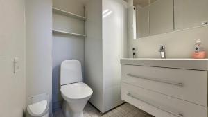 a white bathroom with a toilet and a sink at Koivulantie 11 A 2 in Tahkovuori +22 photos