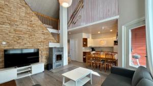 a living room with a couch and a tv and a kitchen at Koivulantie 11 A 2 in Tahkovuori
