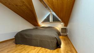 a bedroom with a bed in a attic with a window at Koivulantie 11 A 2 in Tahkovuori