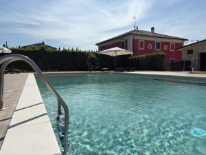 a swimming pool with an umbrella in front of a house at Agriturismo Villa Luisa in Apice