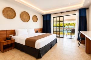 a hotel room with a bed and a balcony at Golden Sands Destination Resorts in Daanbantayan +61 photos