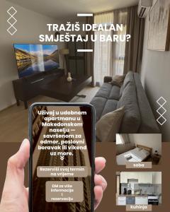 a person holding a smart phone in a living room at Bar holiday apartment Kastro in Bar +2 photos