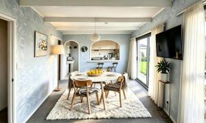 a kitchen and dining room with a table and chairs at Clifftop Coastal Retreat with Ocean Views - Close to Beach & Cafés in Auckland