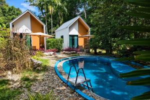 a house with a swimming pool in front of a house at Pool Villa Baan Suan Phrom Khiri in Nakhon Si Thammarat