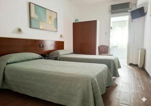 a hotel room with two beds with green blankets at Hostal Urgell in Balaguer +4 photos