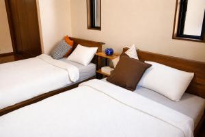 a room with two beds and a small table with at Sumomo in Takayama +18 photos