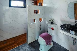 a bathroom with a toilet and a sink at Pool Villa Baan Suan Phrom Khiri in Nakhon Si Thammarat