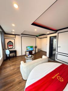 a room with a bed and a couch and a tv at My House Hotel Hanoi in Hanoi