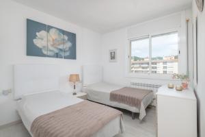 a white room with two beds and a window at Playa 5 min, Terraza, AC, WiFi, Parking in Calella