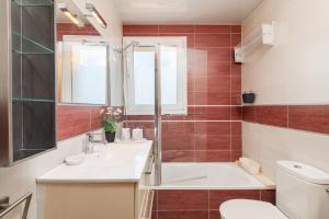 a bathroom with a tub and a sink and a toilet at Playa 5 min, Terraza, AC, WiFi, Parking in Calella +42 photos
