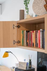 a book shelf with books on it with a lamp at Playa 5 min, Terraza, AC, WiFi, Parking in Calella